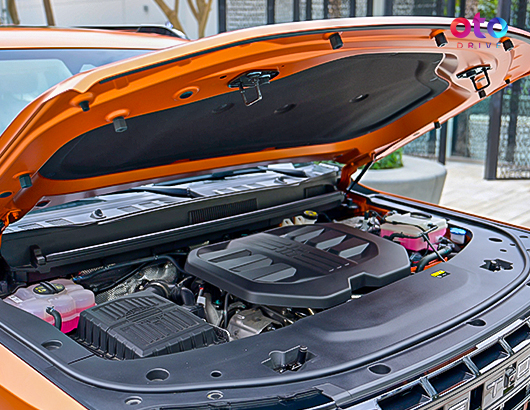 Open car hood showing the powerful engine bay compartment of an orange Jetour G700 SUV.